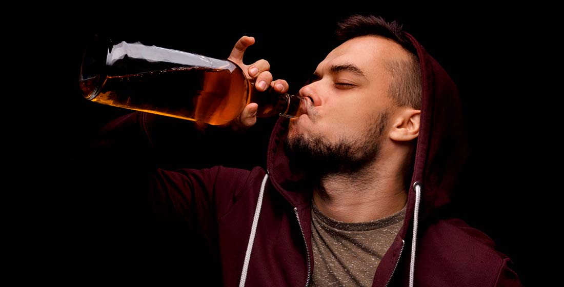 мужчина пьет алкоголь из бутылки